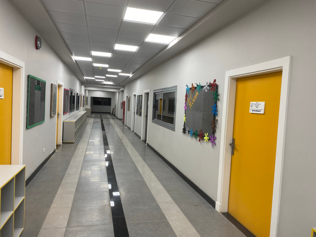 An ESE corridor with student work and yellow classroom doors